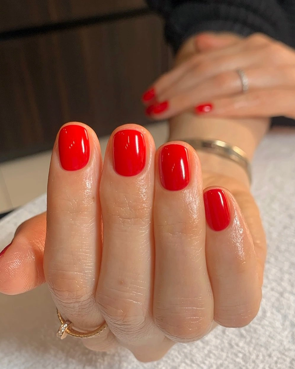 Glossy red short rounded square nails in close view