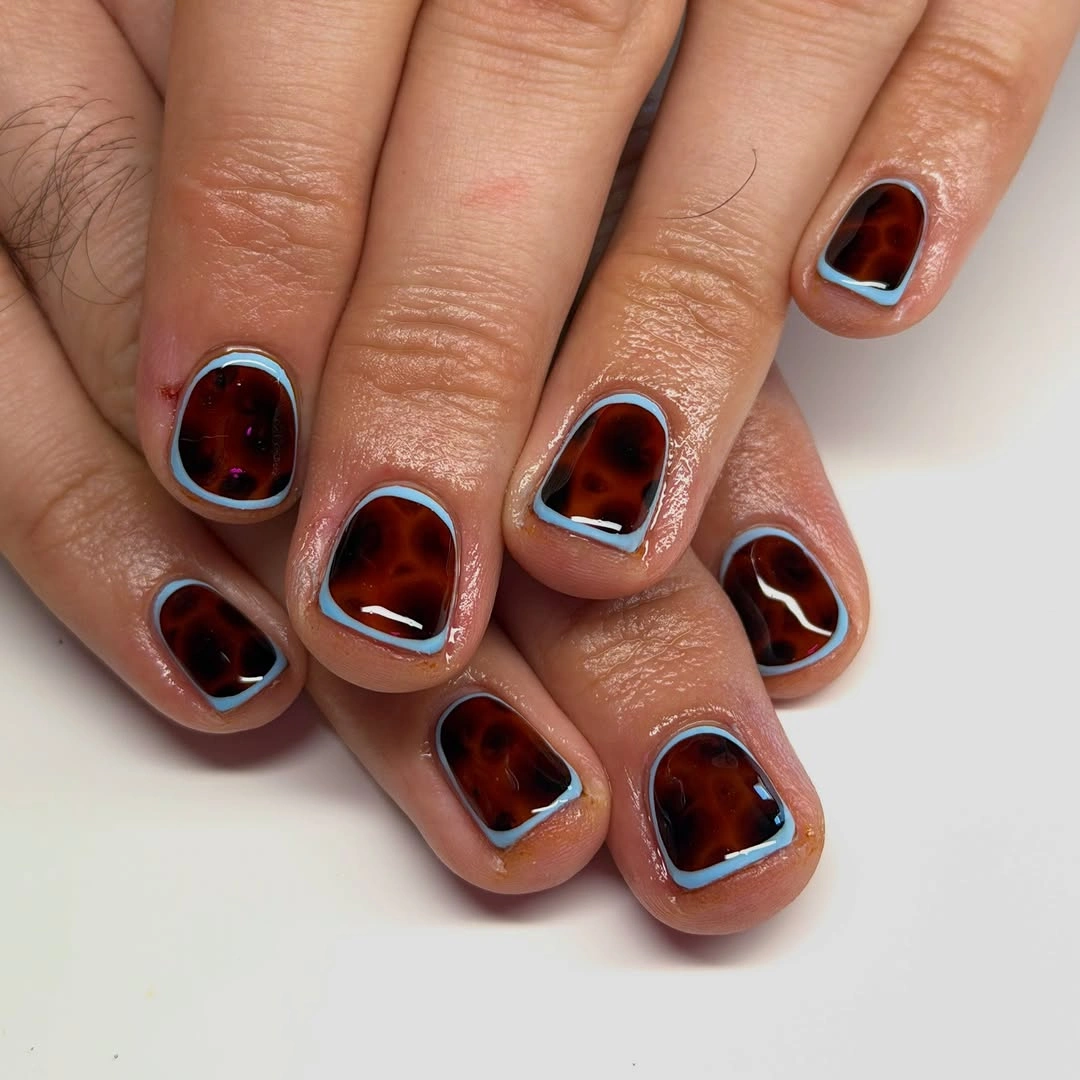 Extremely short brown nails with pale blue borders
