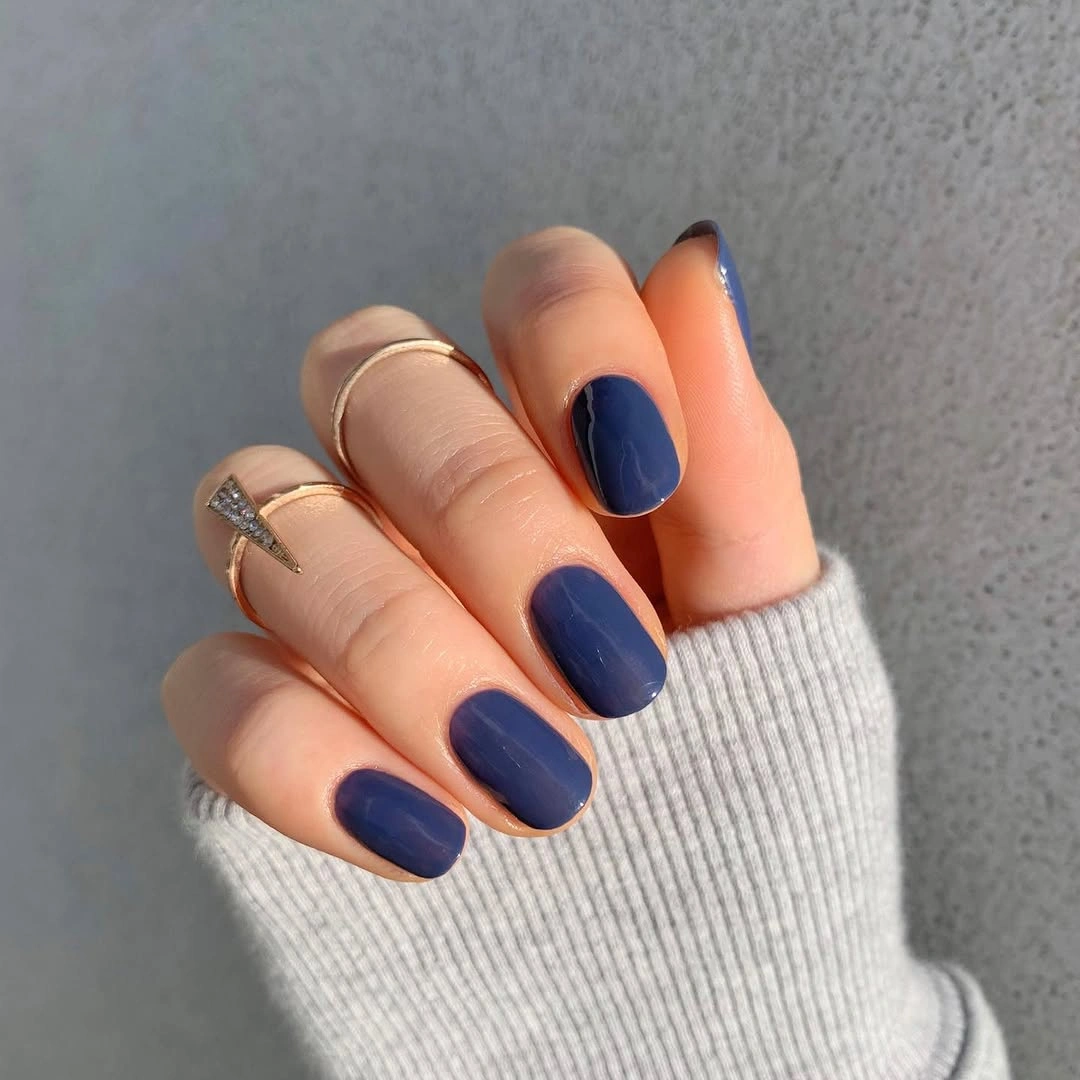 Short rounded nails in glossy muted denim blue