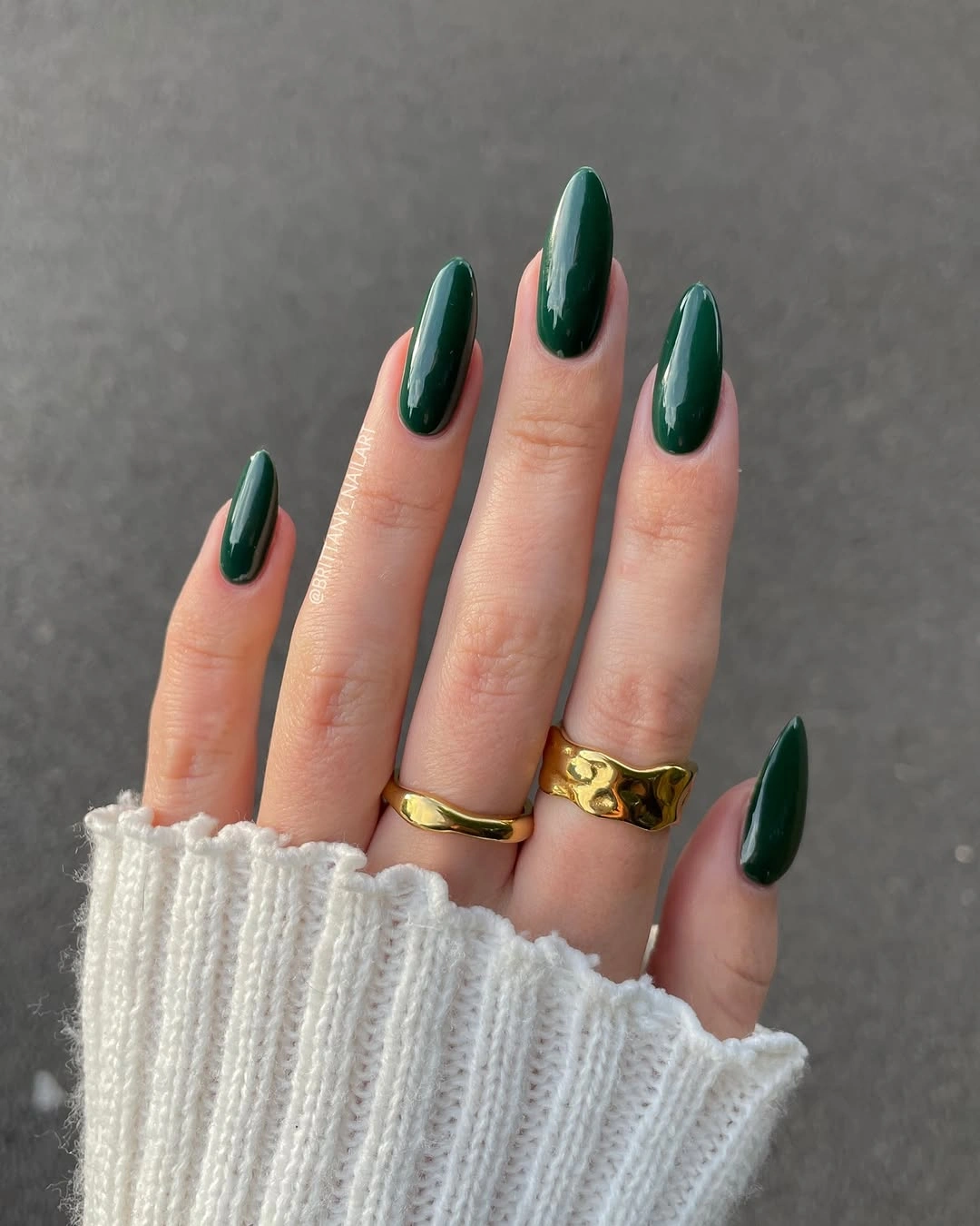 Long glossy emerald almond nails with gold rings