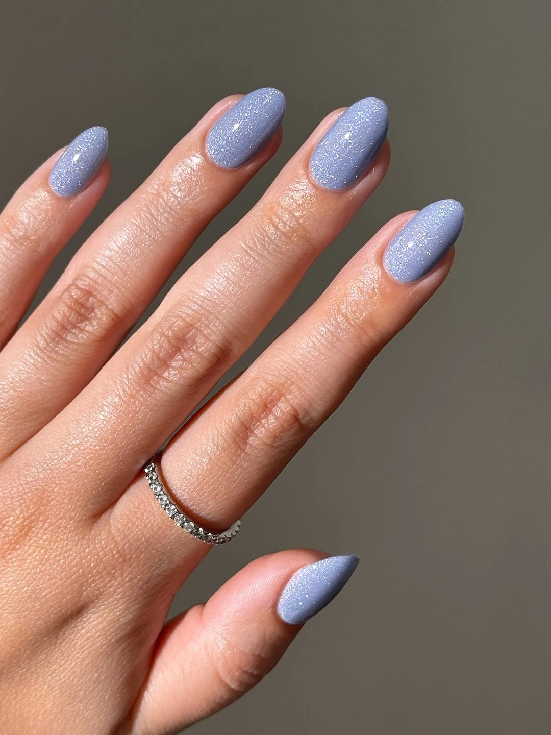 Pale periwinkle almond nails with fine sparkling texture