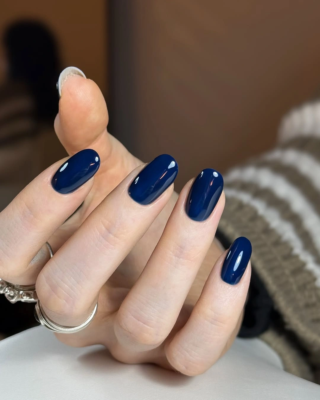 Glossy deep cobalt almond nails on a fair hand