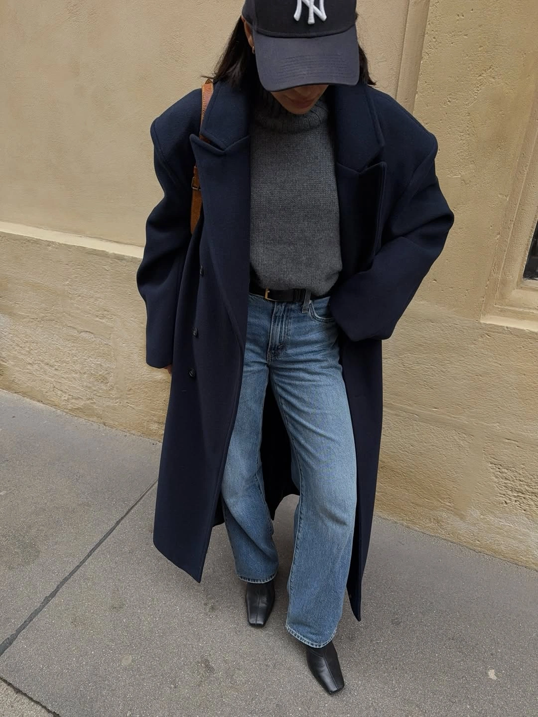 Navy coat with gray knit, wide jeans and pointed black boots