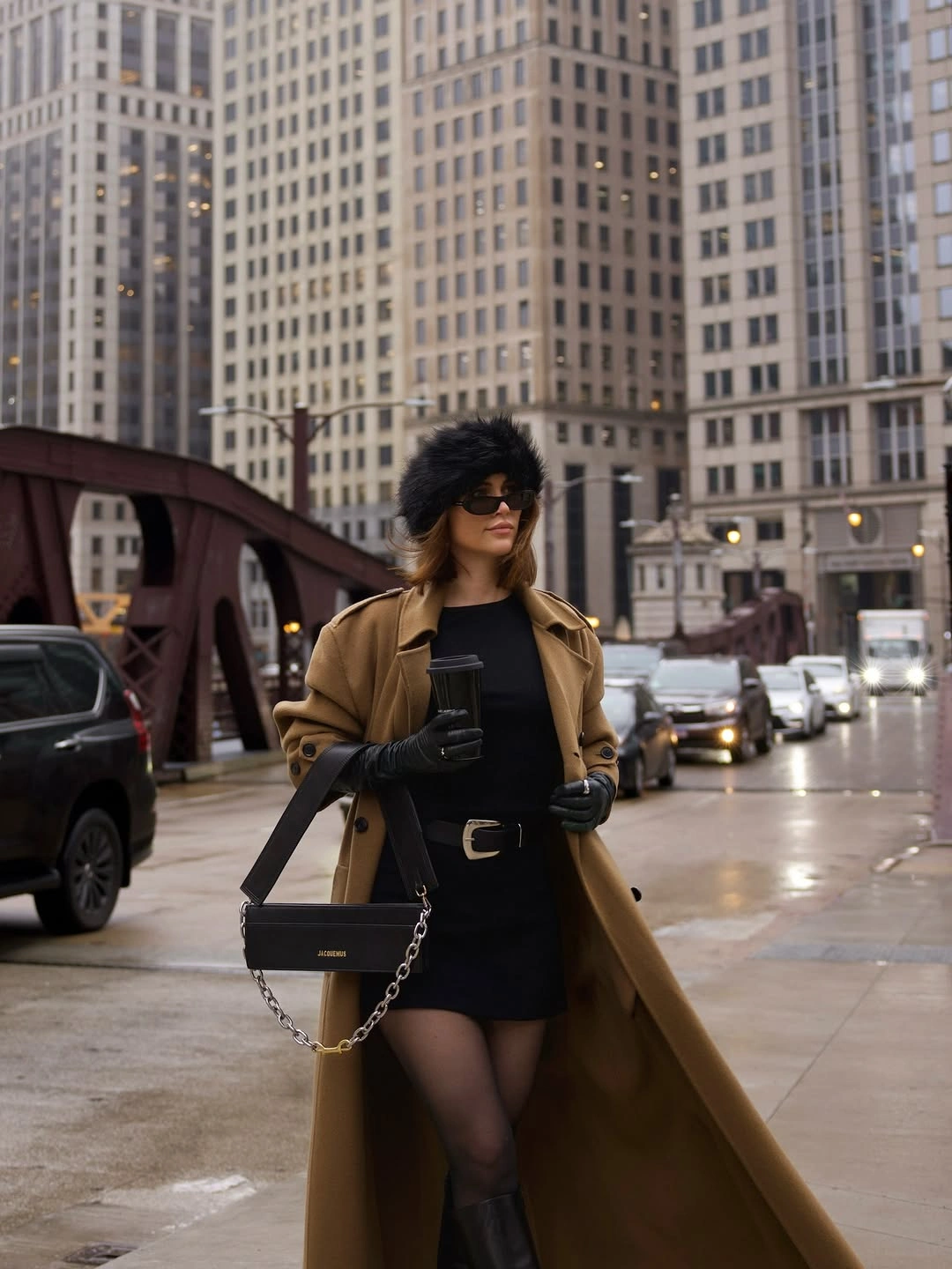 Camel coat with black tights, tall boots and structured bag
