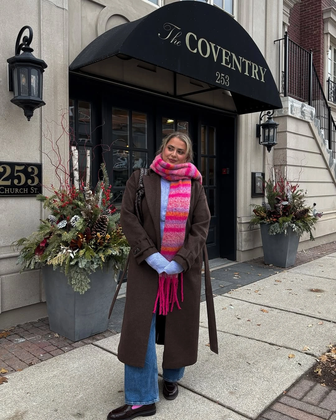 Brown coat with blue denim and long multicolor striped scarf