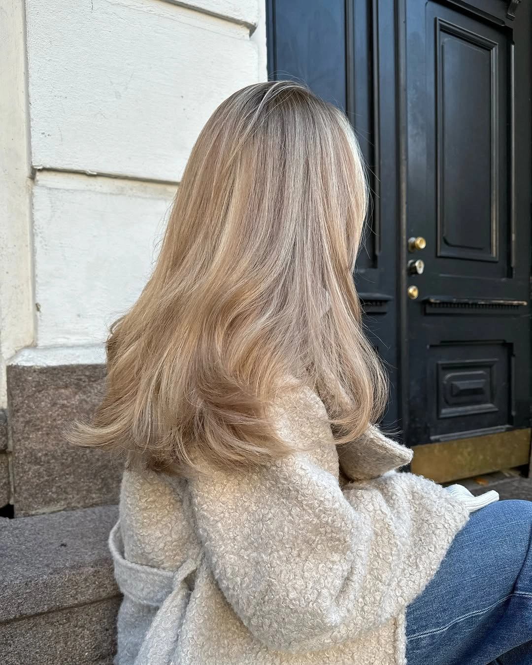 Back view of layered beige blonde hair with turned ends