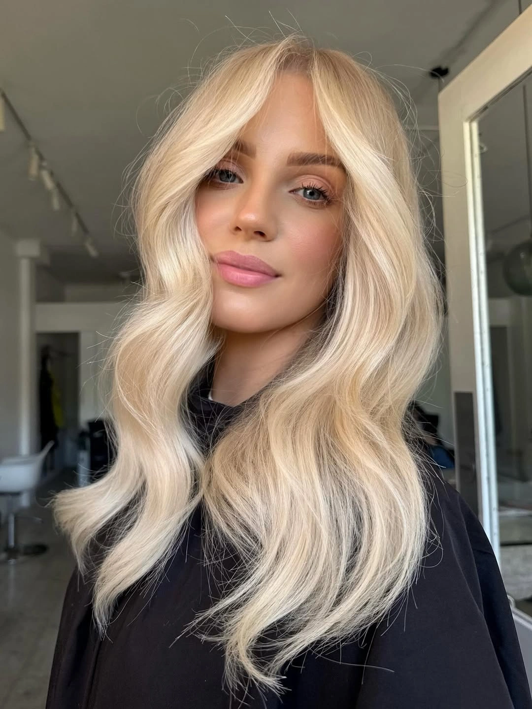 Long creamy blonde waves with soft curtain-style front layers