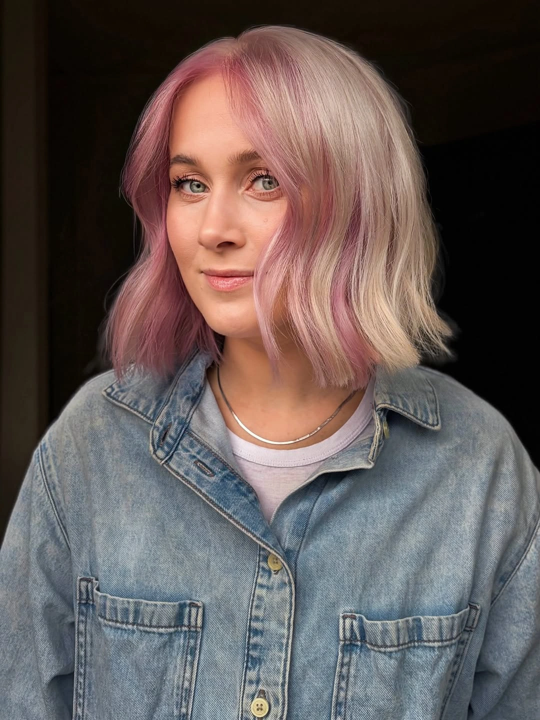 Wavy blonde bob with pink-lavender face-framing color