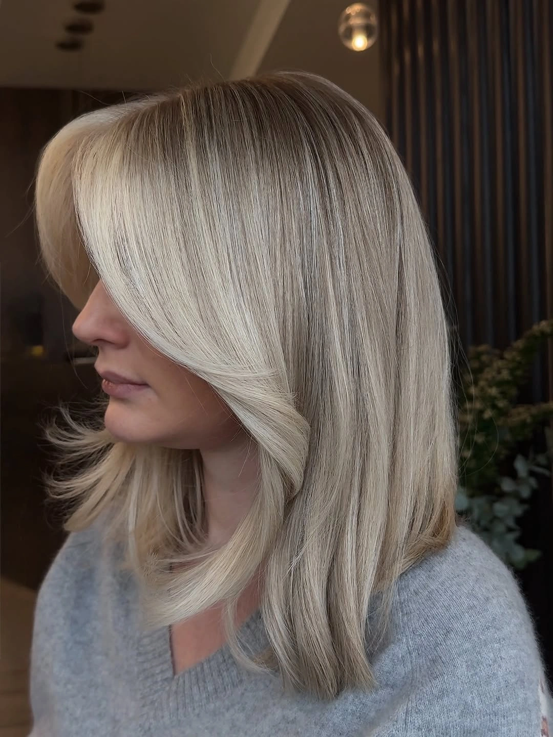 Smooth ash blonde midlength hair with side-swept front layer