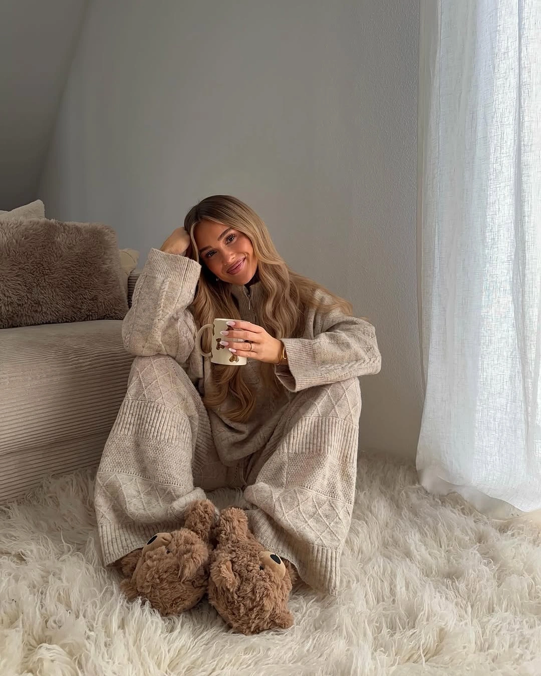 Beige knit sweater and trousers with plush brown footwear
