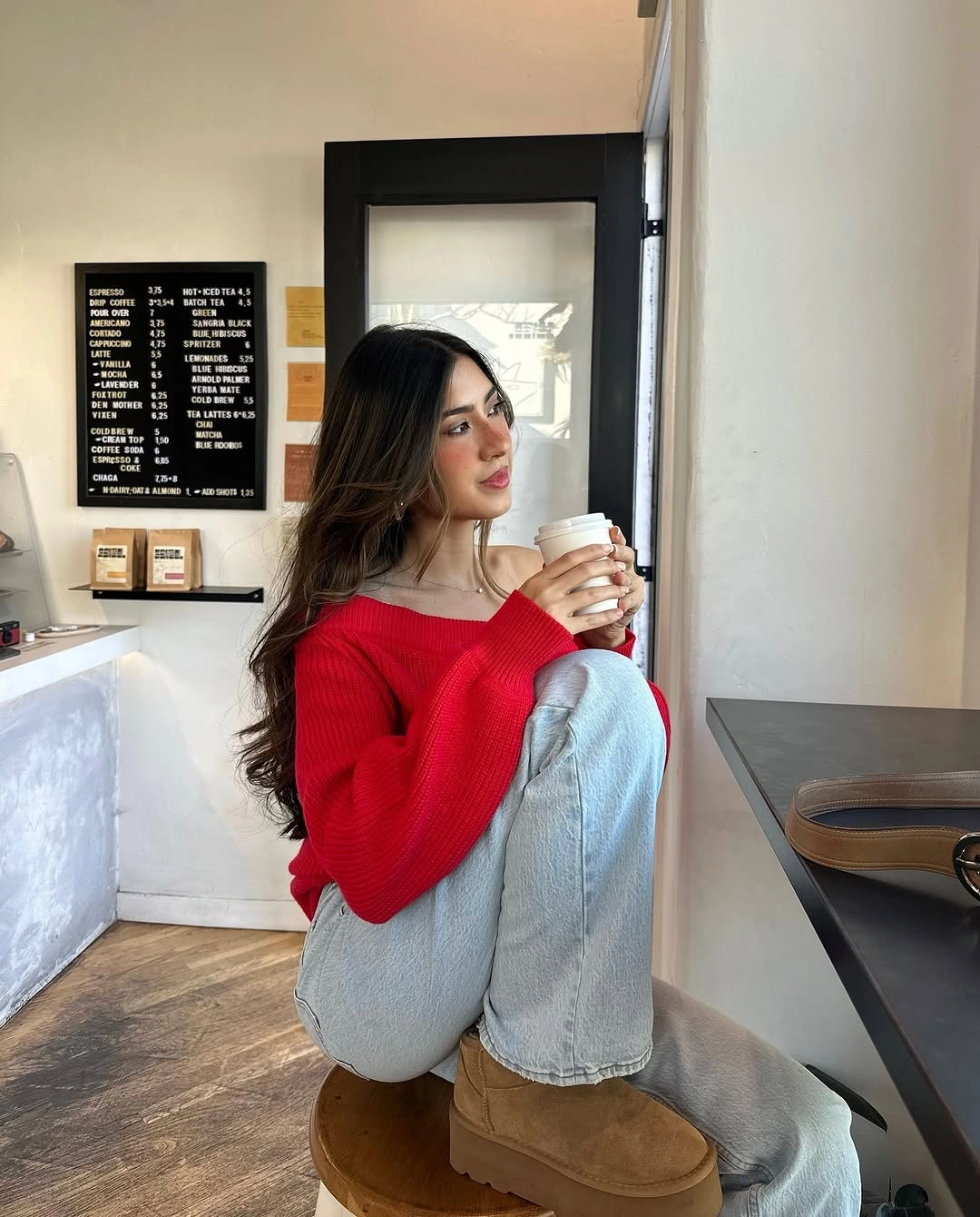 Bright red sweater with cuffed jeans and tan boots