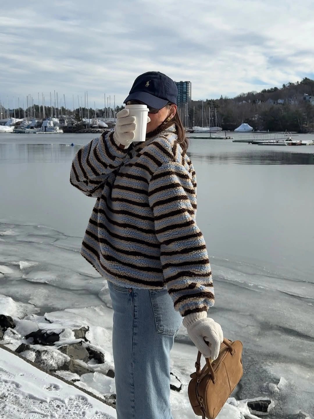 Striped oversized sweater with light jeans and white gloves
