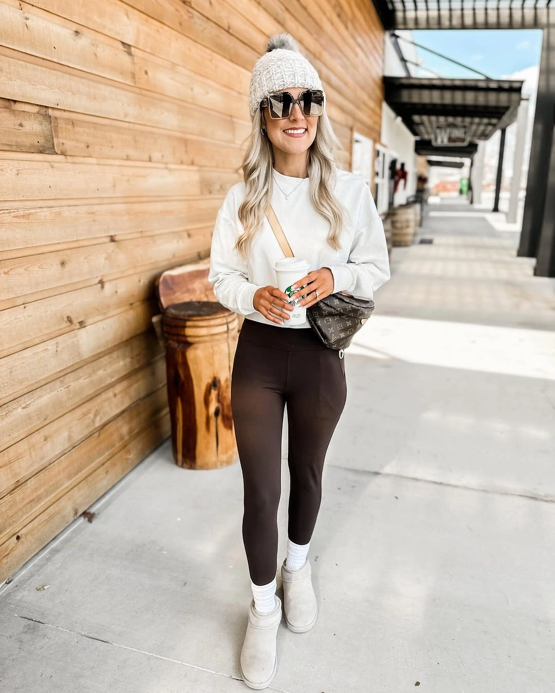 White sweater and beanie with black leggings and sneakers