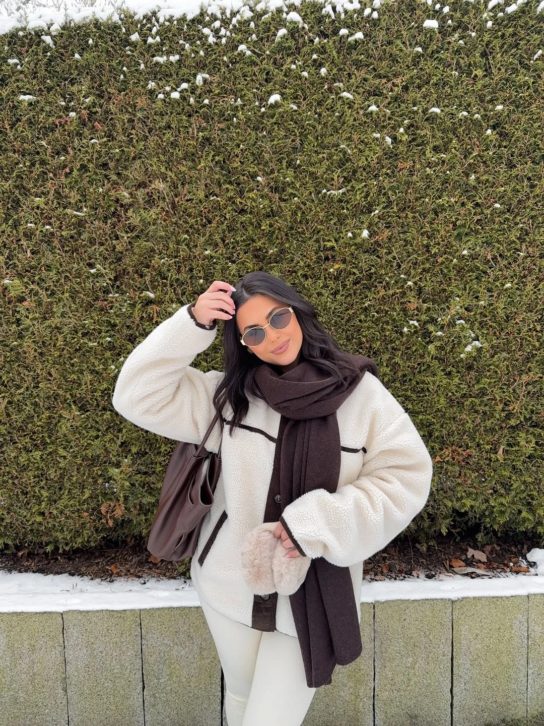 White plush jacket with long dark scarf and sunglasses
