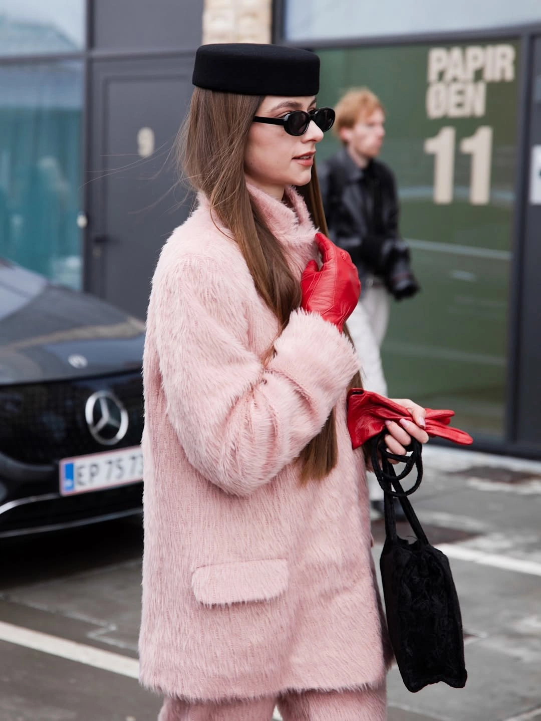 Pale pink fuzzy coat with red gloves and black hat