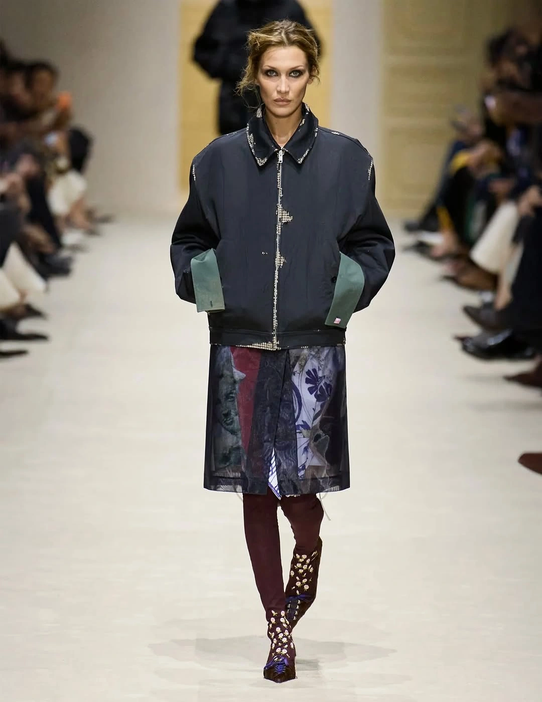 Oversized dark bomber jacket over sheer skirt and burgundy tights