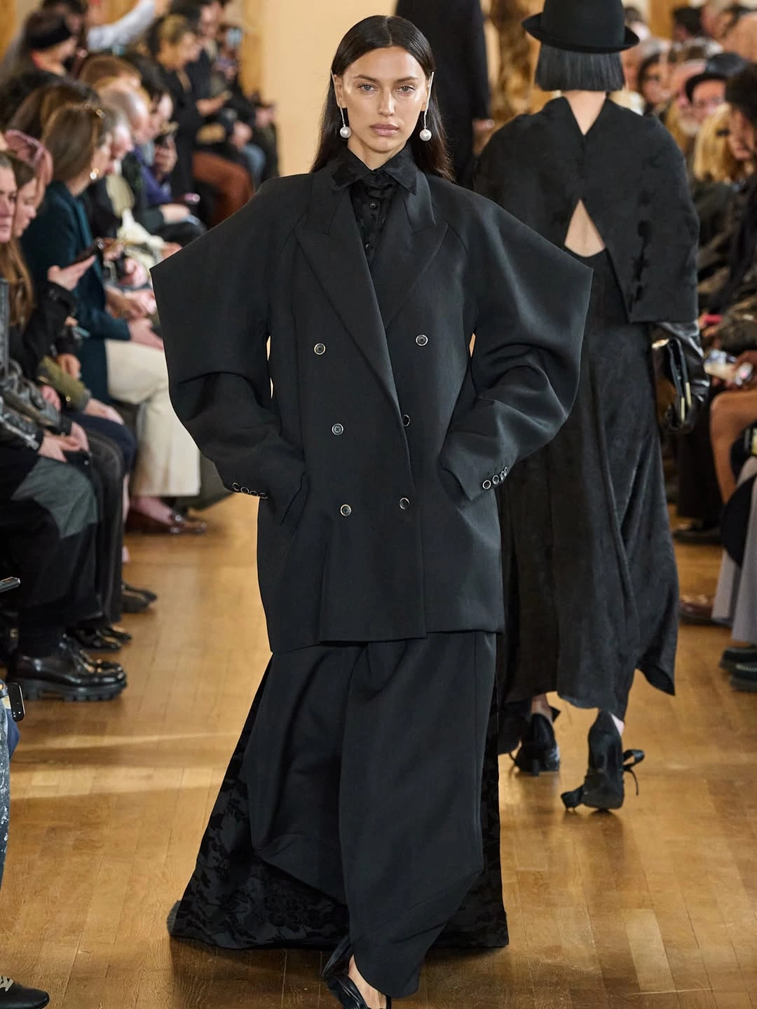 Oversized black blazer with long black skirt and pearl earrings