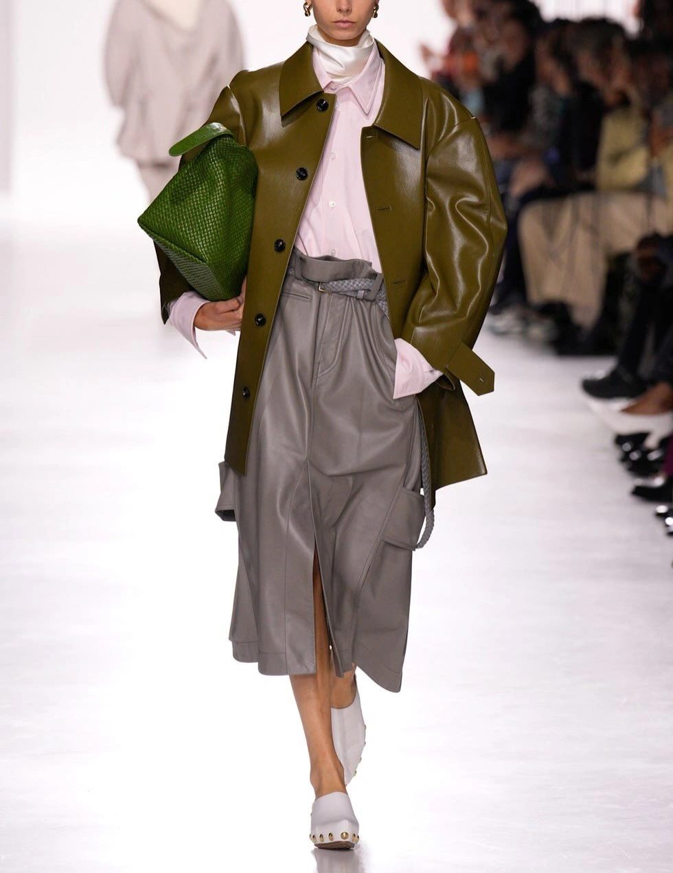 Glossy olive coat with pink shirt and gray skirt
