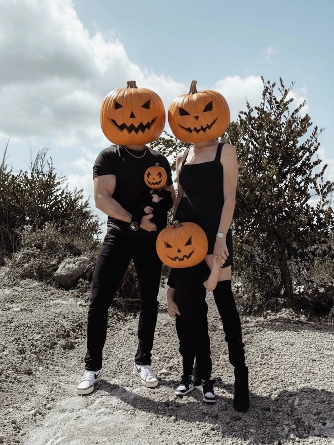 Black family costumes with oversized orange pumpkin headpieces