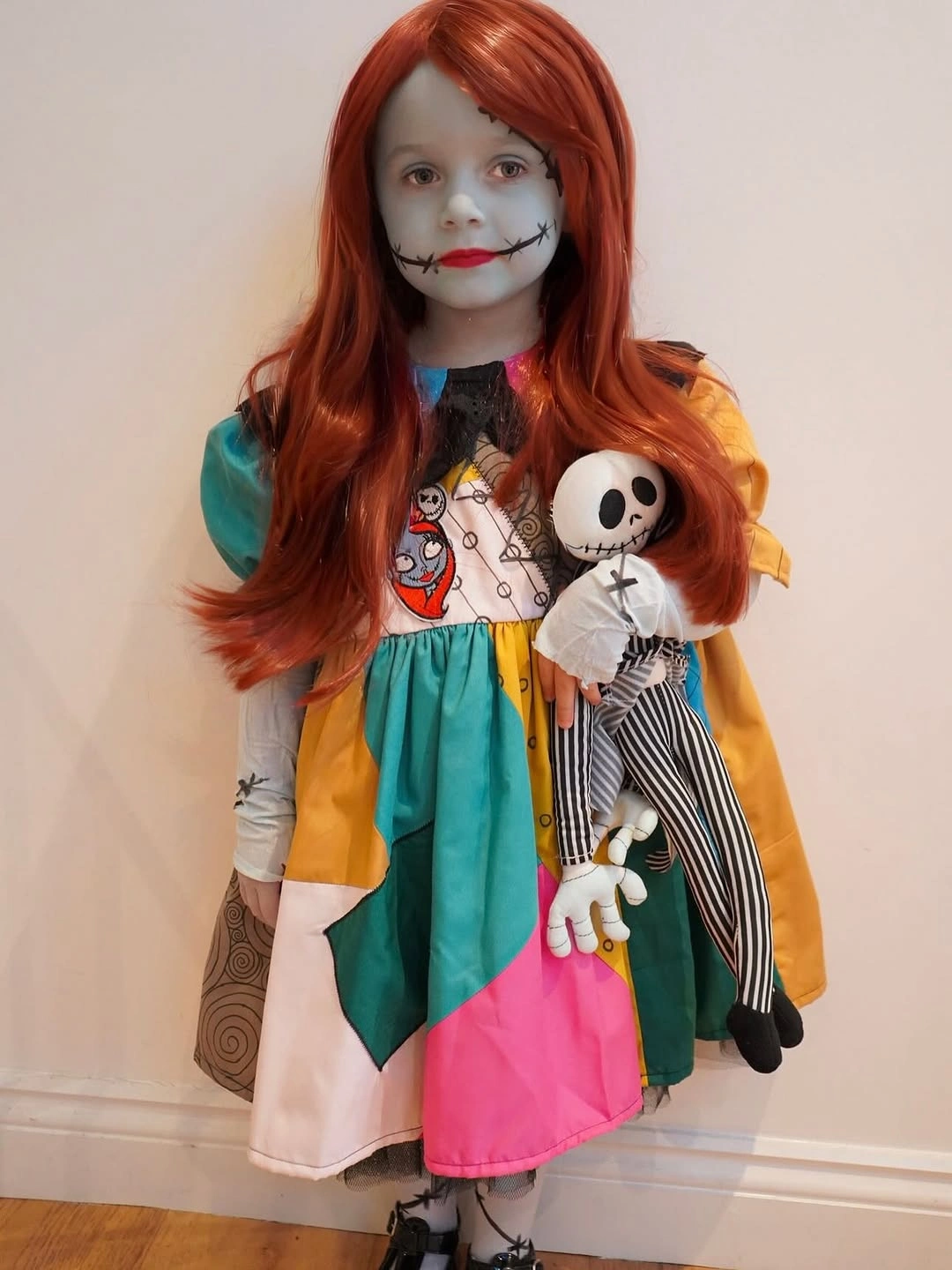 Bright panelled girls costume with striped skeleton doll