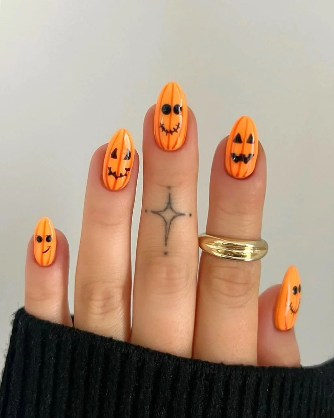 Long orange pointed nails with black pumpkin faces