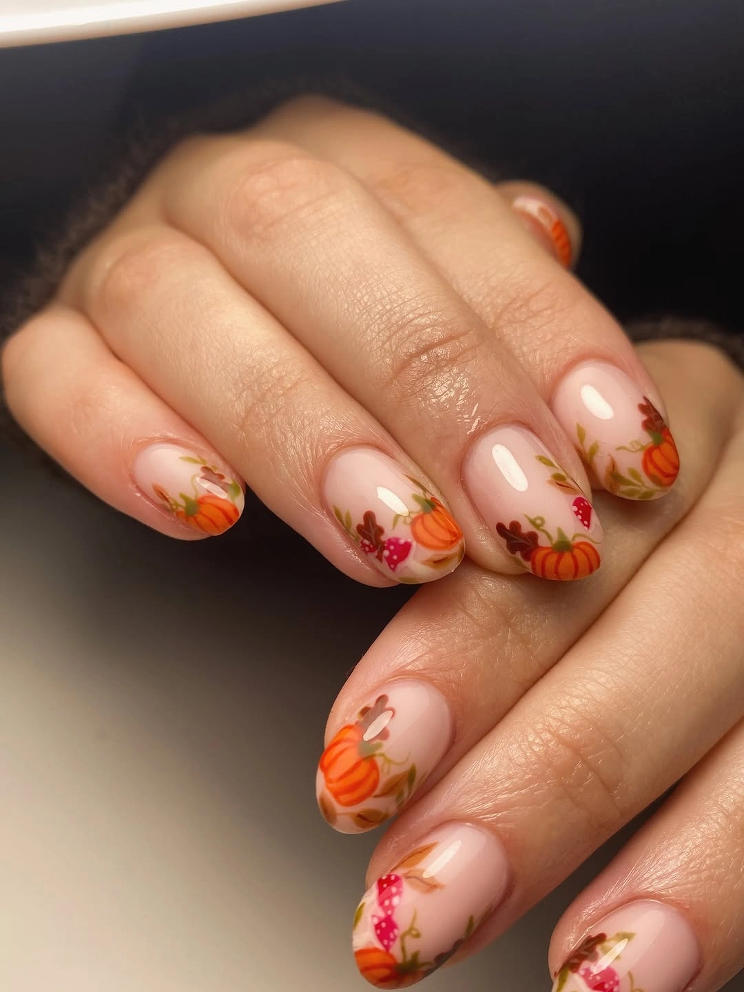 Nude nails with orange tips and fine pumpkin accents