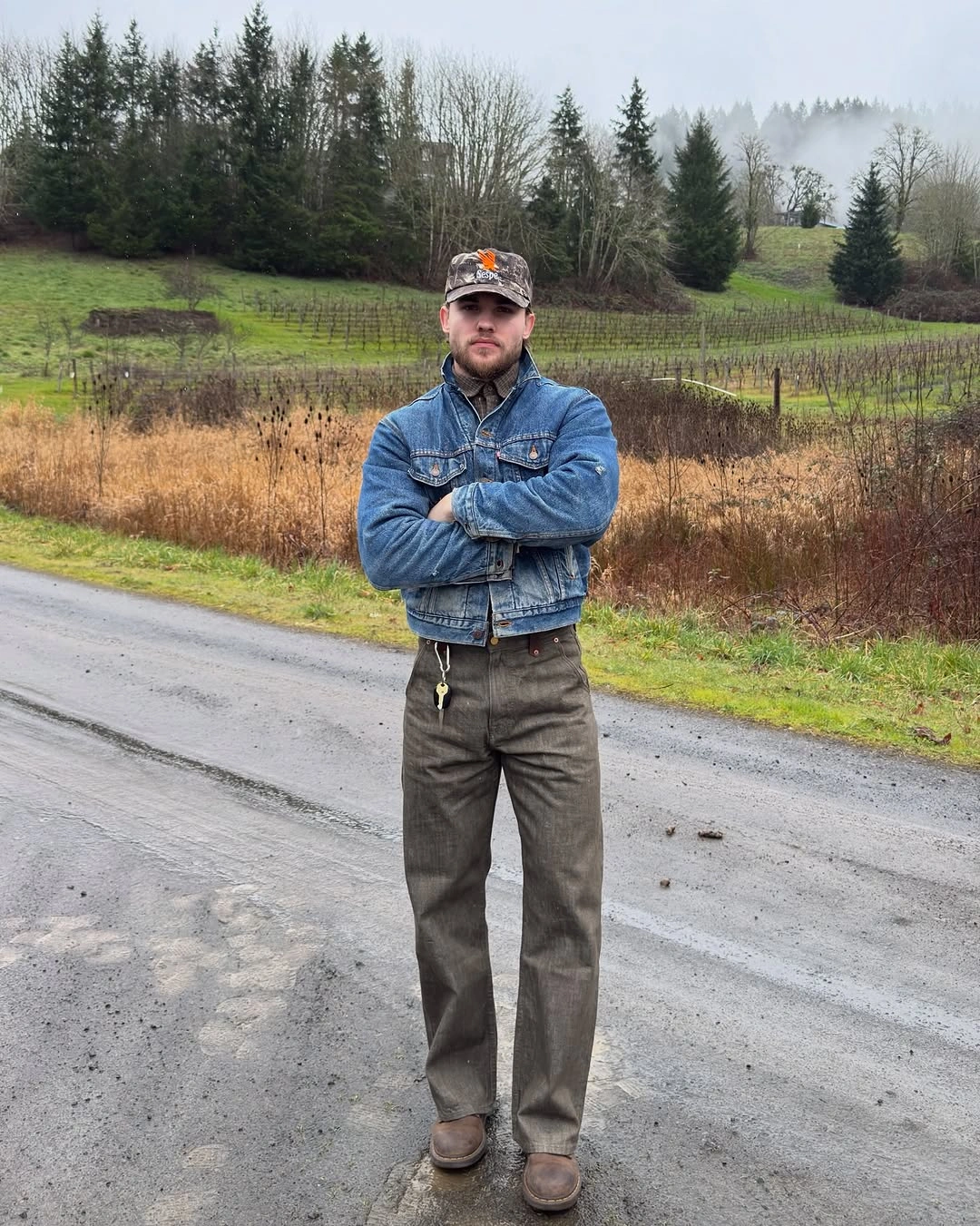 Man in cropped denim jacket, high-neck layer and olive trousers