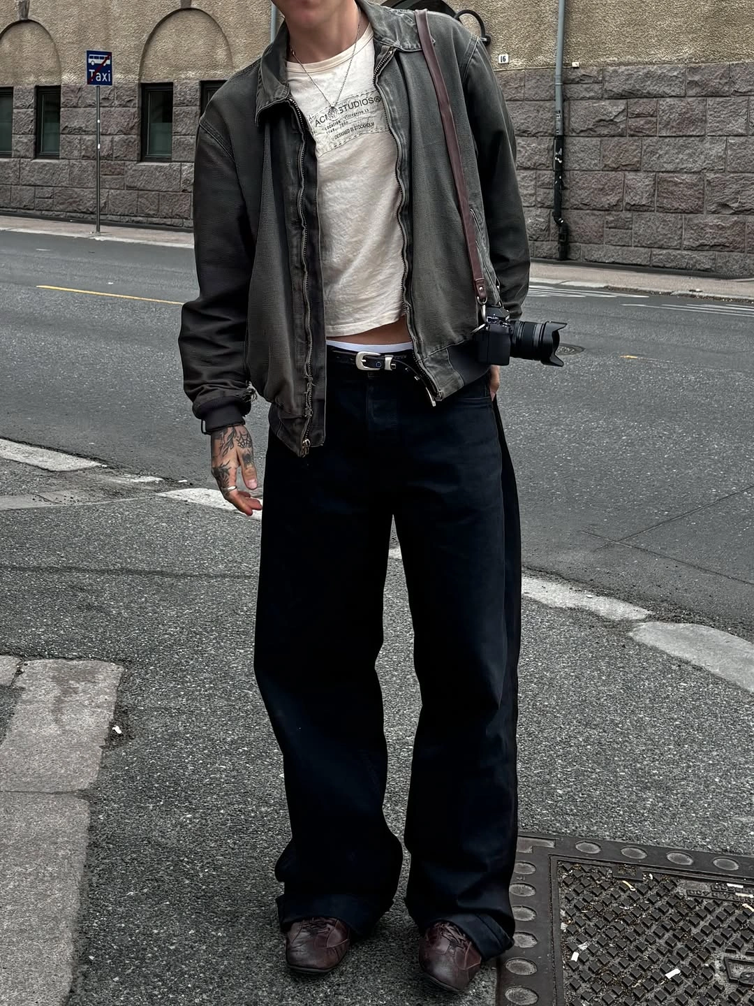 Man in gray zip jacket, printed tee and wide black trousers