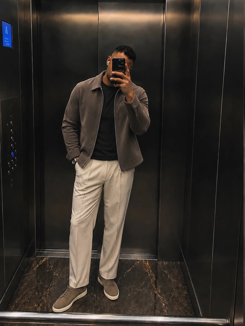 Mirror selfie in taupe jacket, black tee and cream trousers