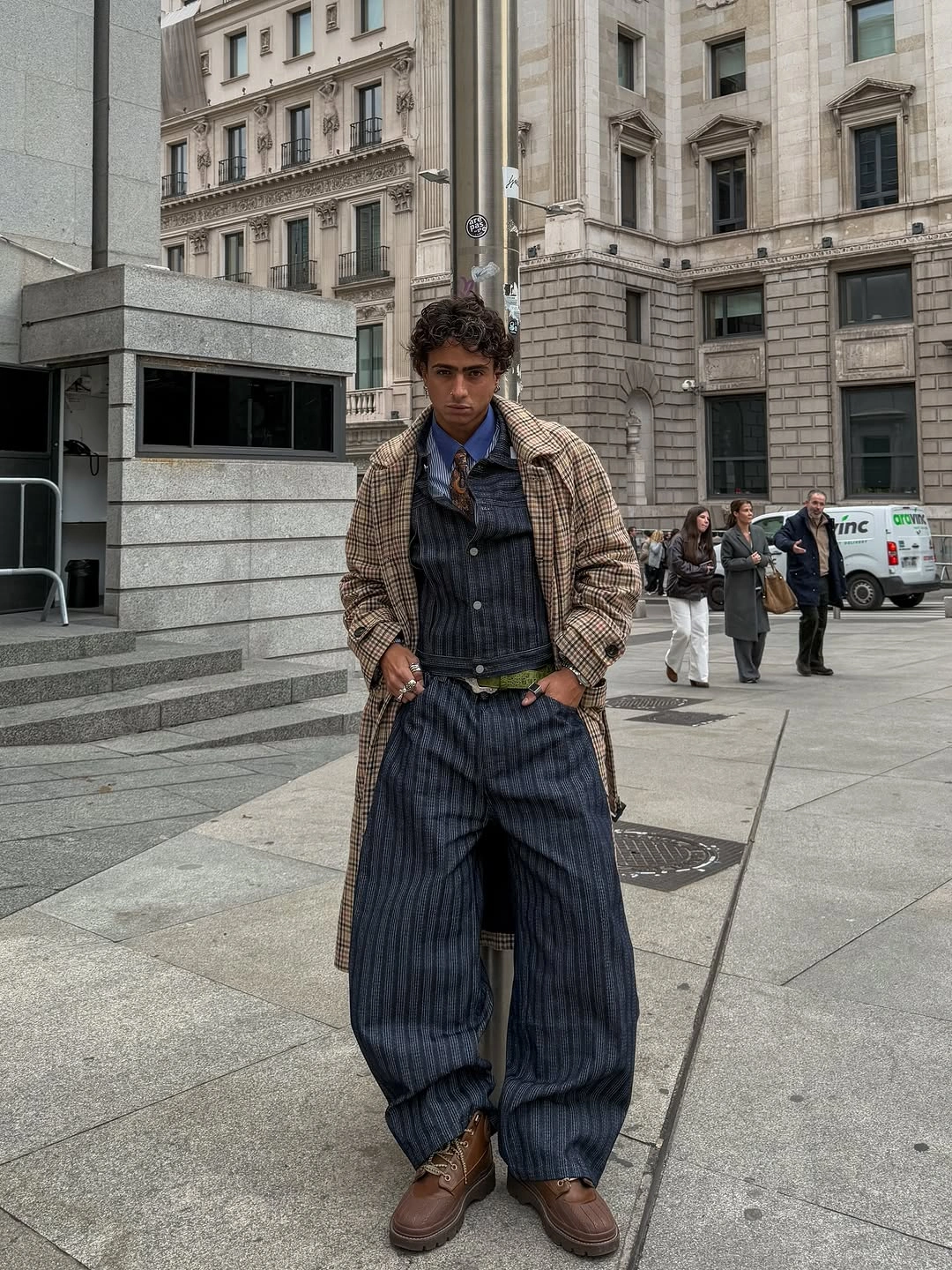 Man in long plaid coat, indigo layers and striped trousers