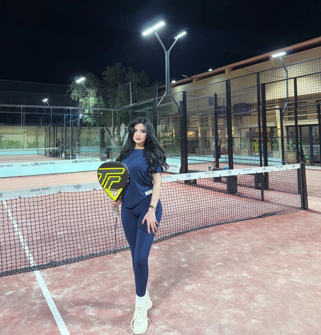 Deep navy matching padel set with neon yellow racket indoors