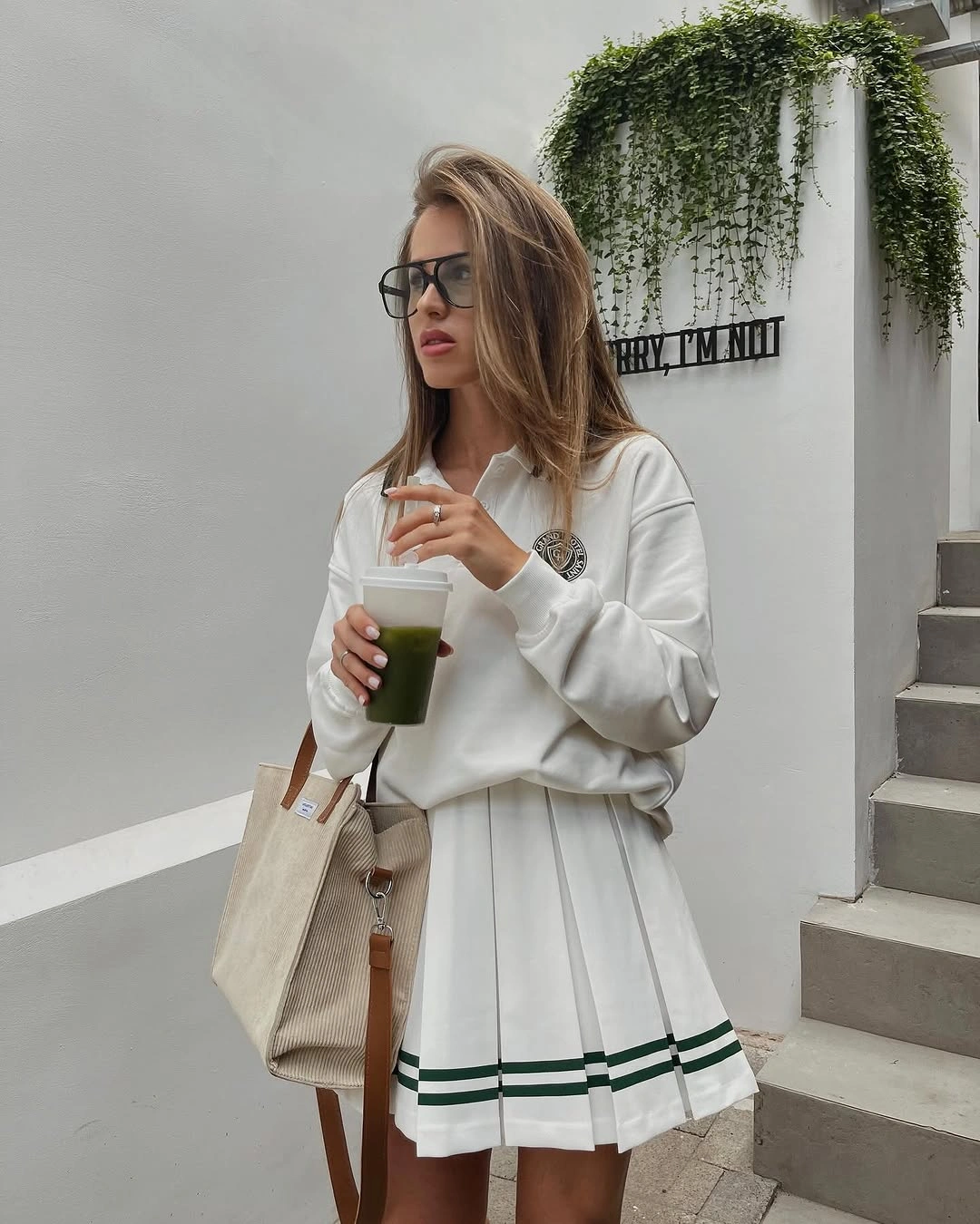 White collared sweatshirt and pleated skirt with green stripes