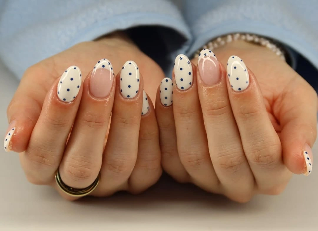 Cream oval nails with navy dots and dotted pink tips