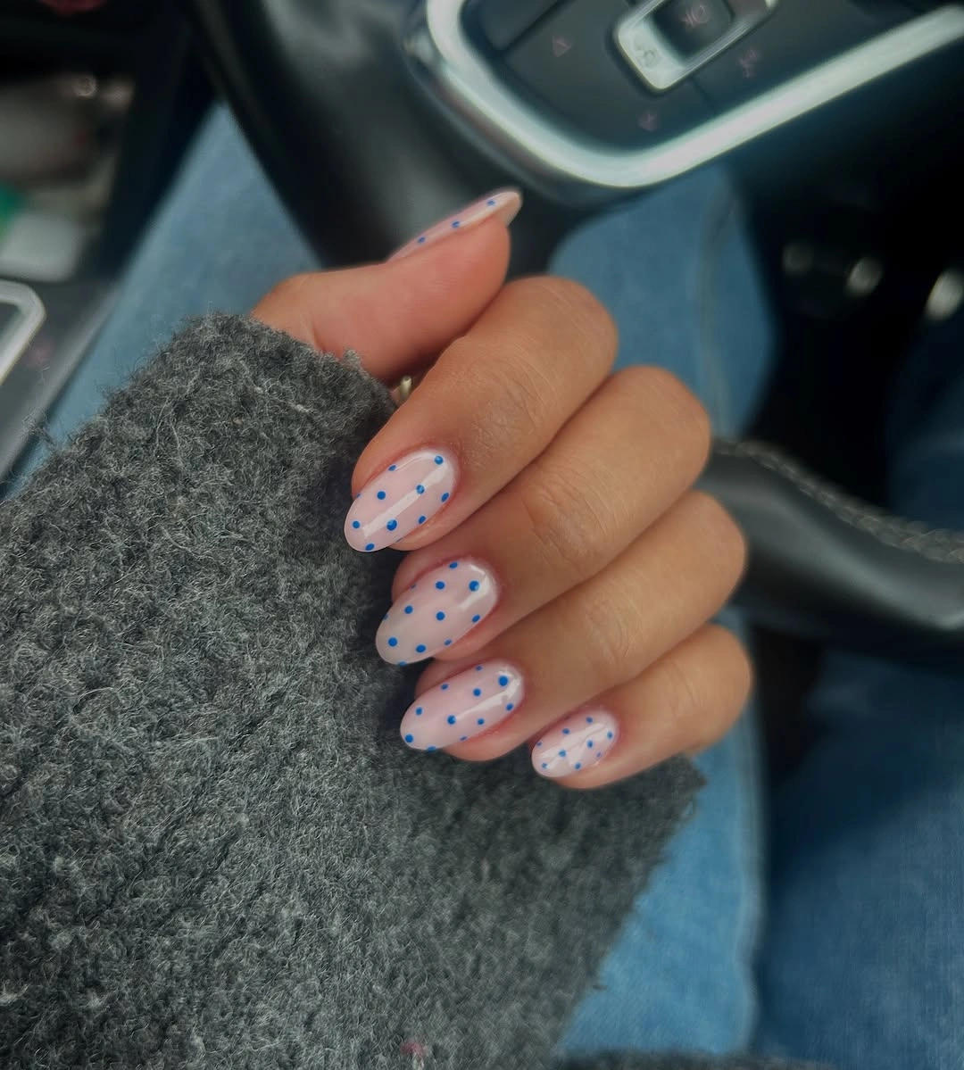 Pale pink oval nails with bright blue dots