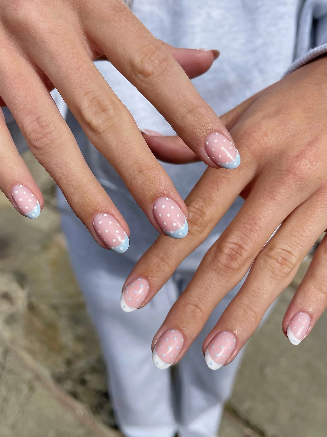 Pastel pink almond nails with blue and white dotted tips