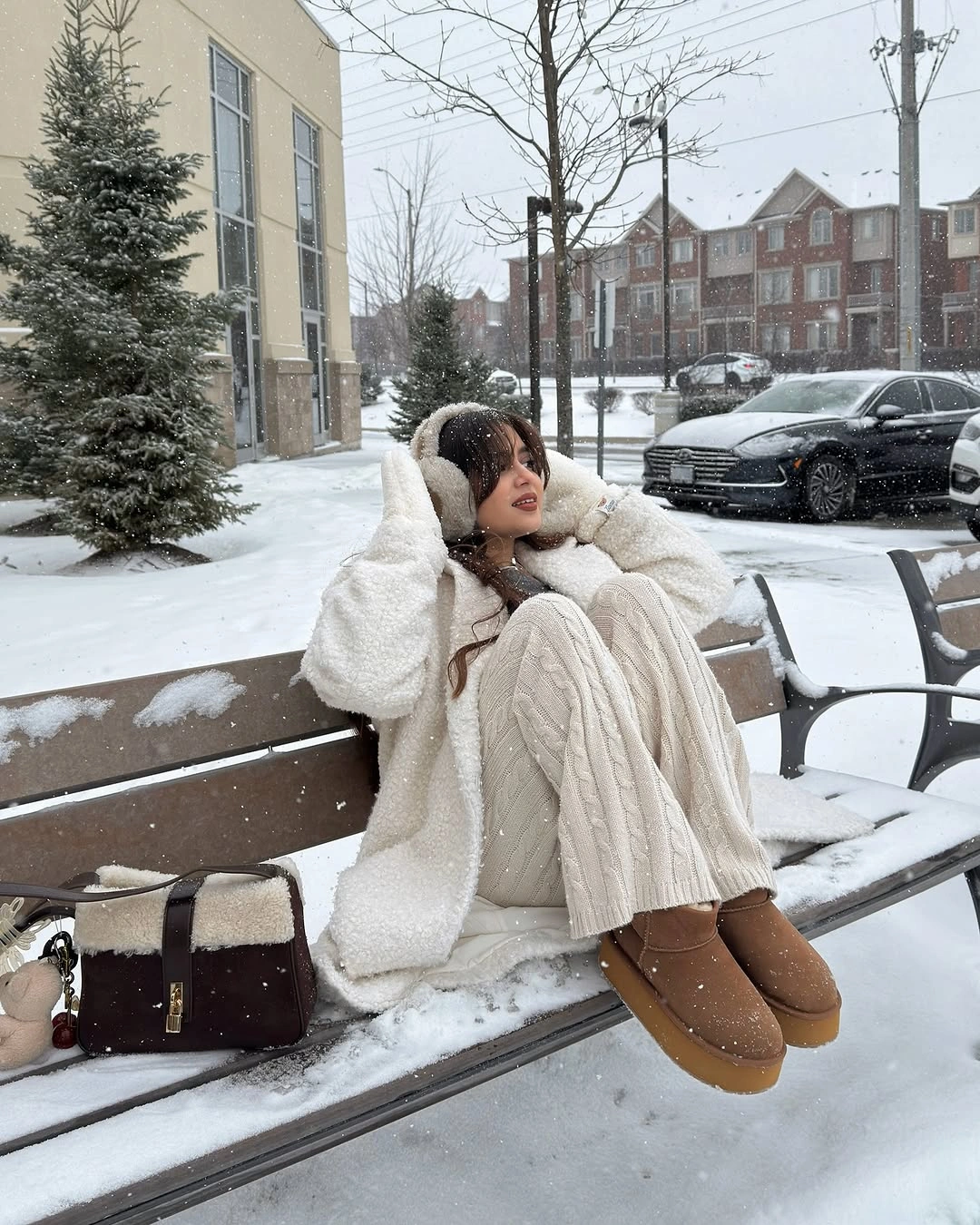 Black jacket and skirt with white beanie and tan boots