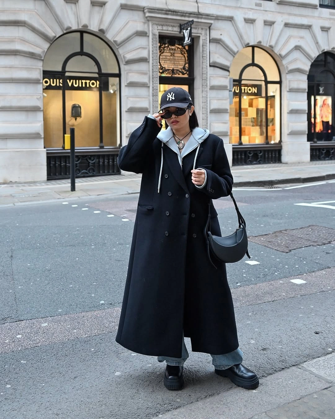 Long black coat with gray hoodie and wide black trousers