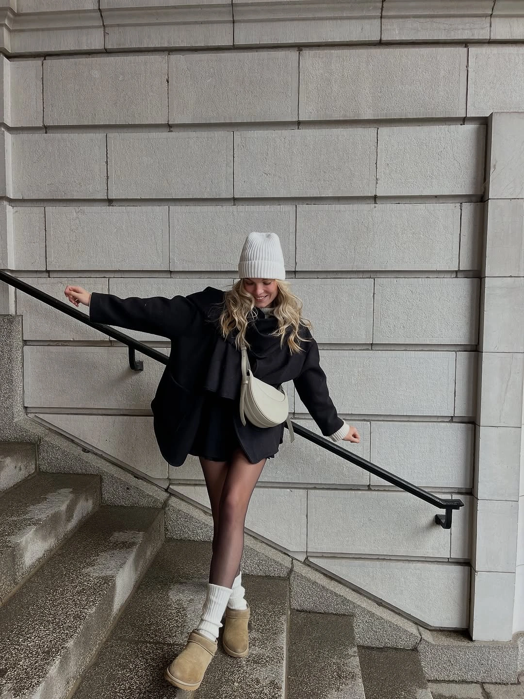 Black jacket and skirt with pale accessories and tan boots