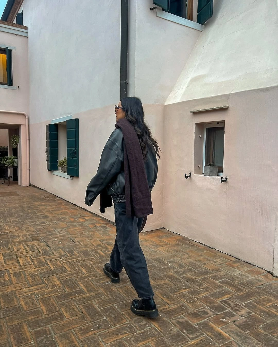 Dark jacket with long burgundy scarf and gray jeans