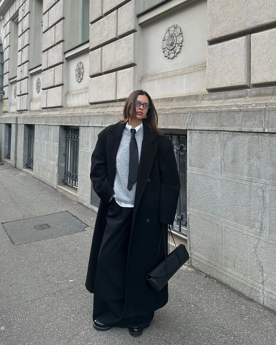 Gray-white sneakers with black puffer and wide trousers