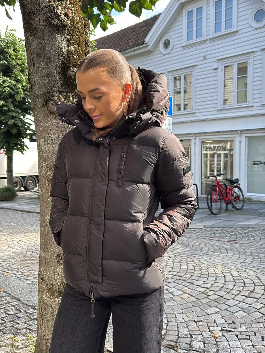 Dark gray hooded padded jacket with black trousers