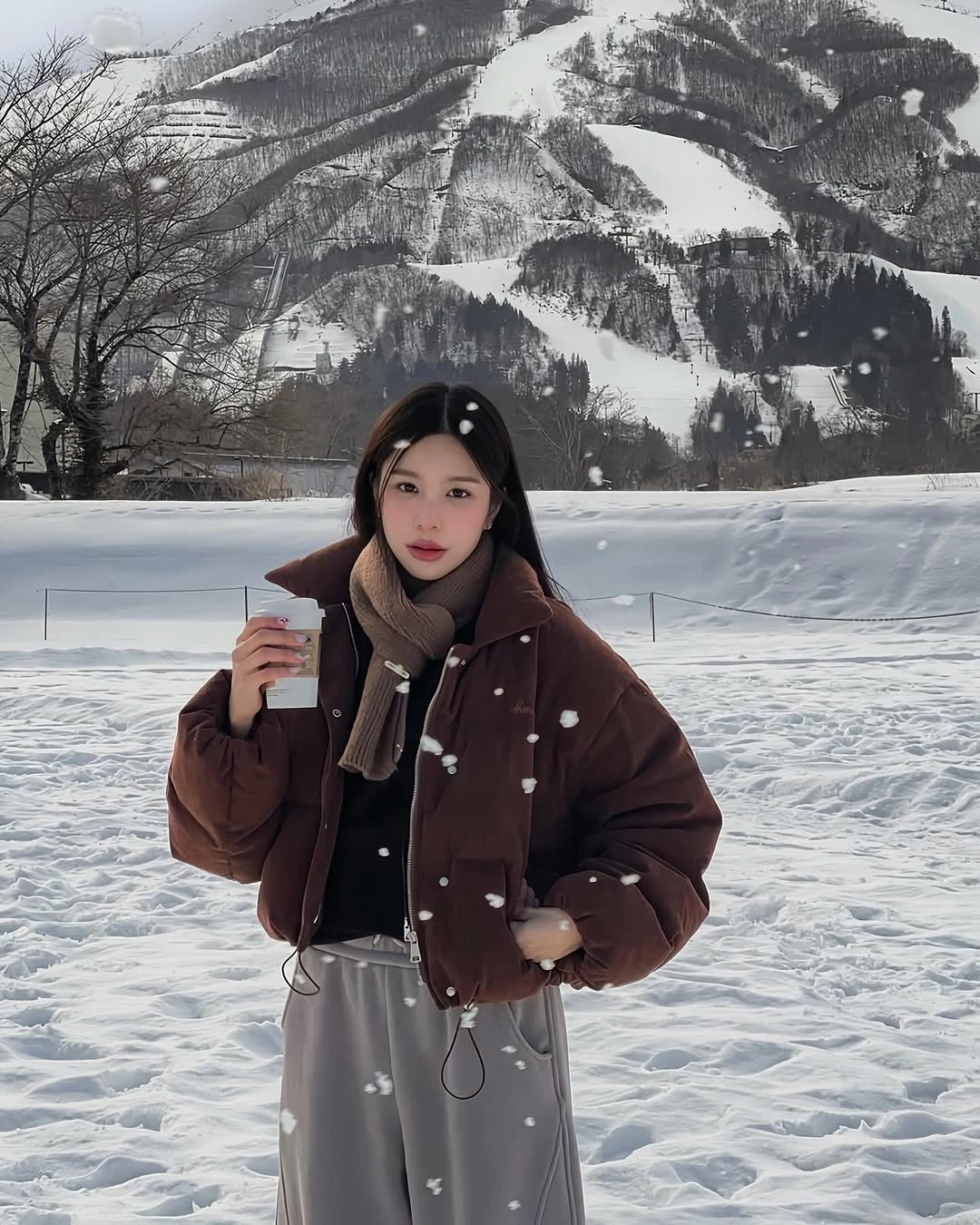 Brown cropped puffer jacket with beige scarf and gray sweatpants