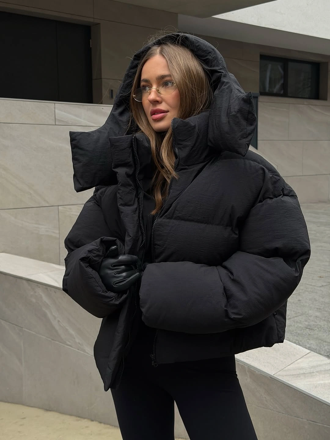 Oversized black hooded puffer with gloves and glasses