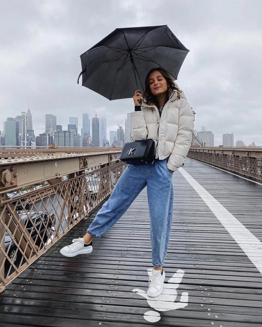 White cropped puffer with jeans, sneakers, umbrella and crossbody bag
