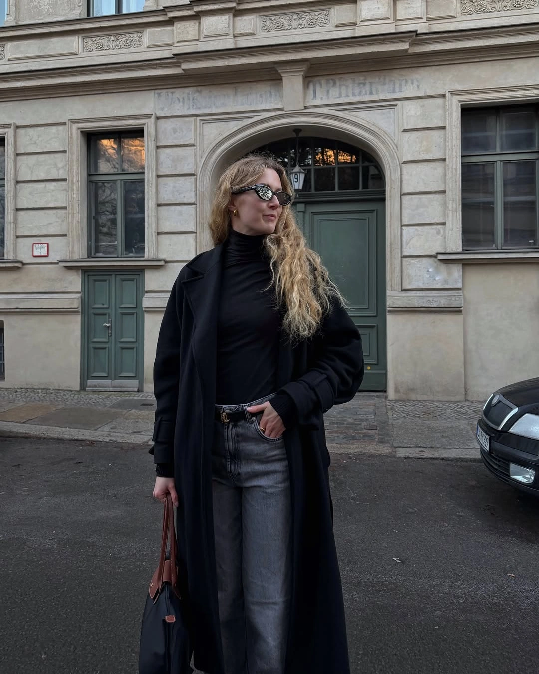 Long black coat with black top and gray straight pants