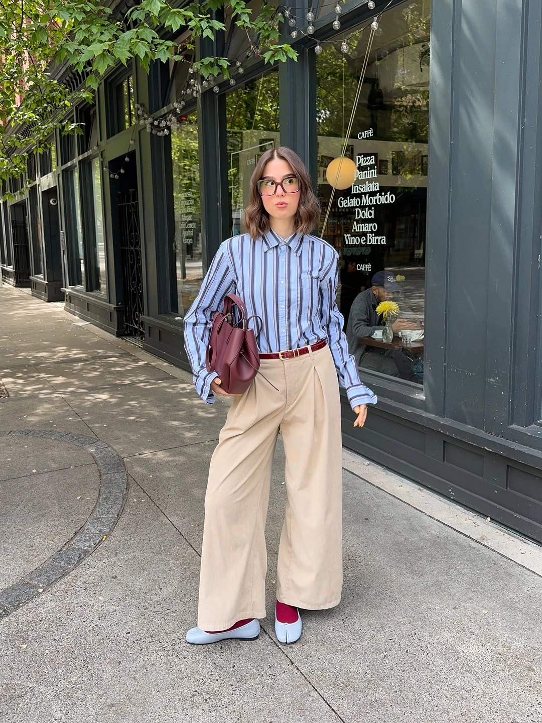 Blue striped shirt with cream wide trousers and red accents