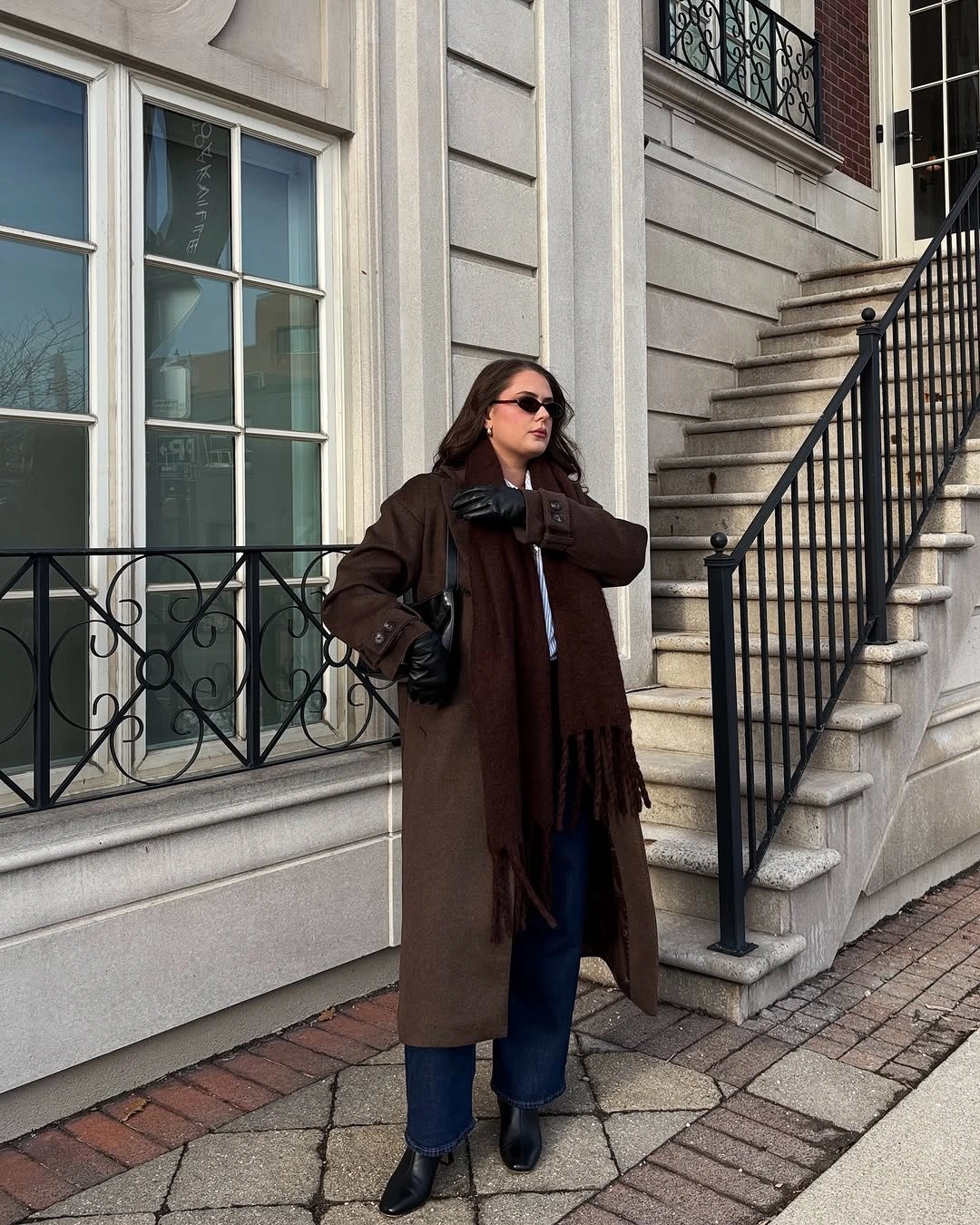 Long brown coat with fringed scarf, jeans and black ankle boots
