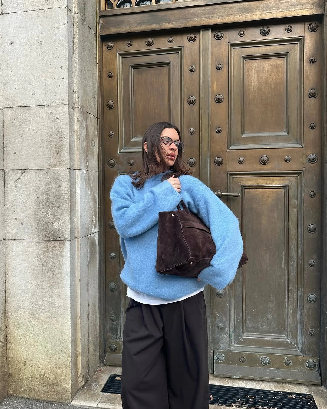 Sky blue oversized sweater with black wide trousers and tote