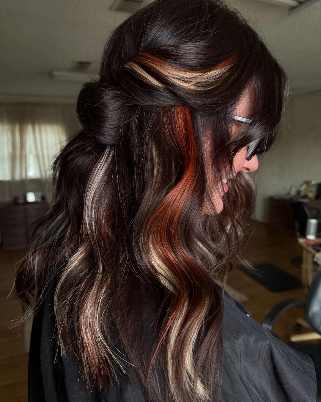 Long dark half up hair with copper blonde streaks