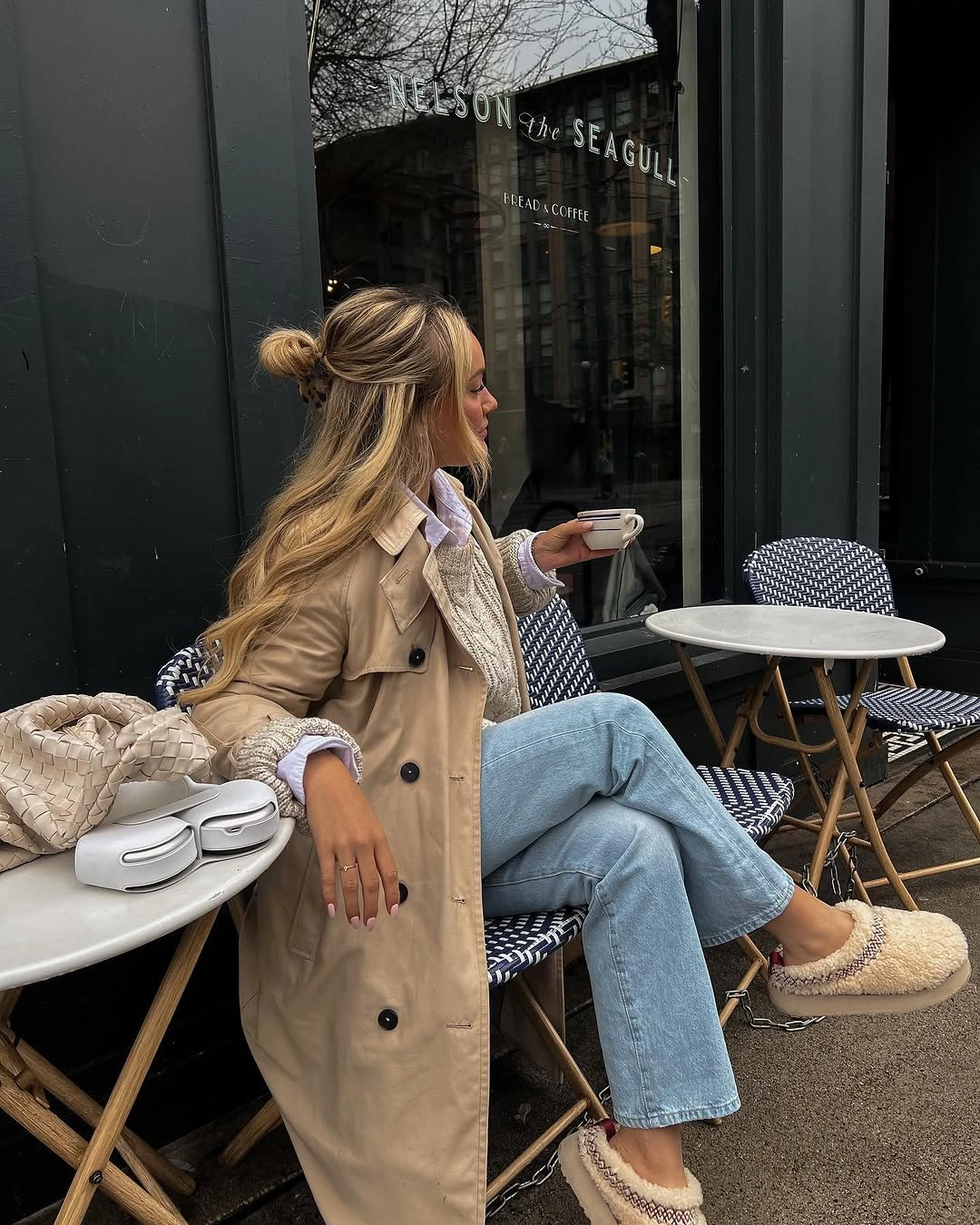 Beige trench coat with pale jeans and tan slip-ons